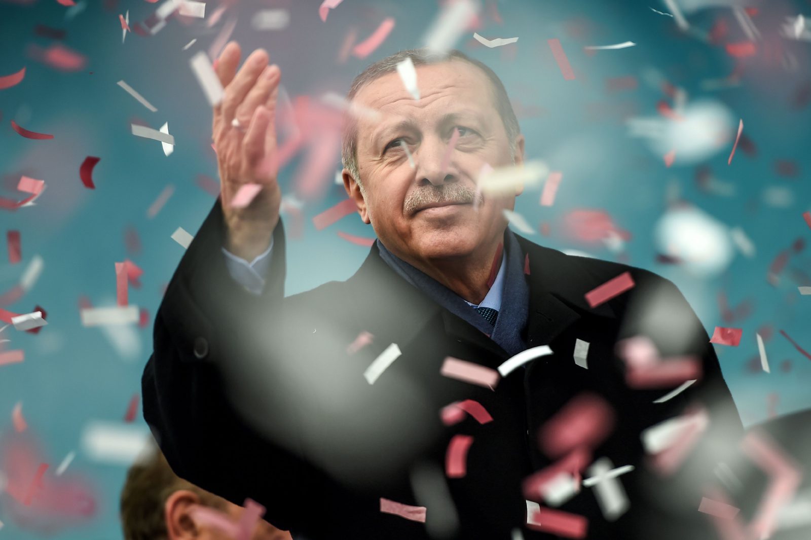 TOPSHOT - Turkish President Recep Tayyip Erdogan gestures amid confetti during a rally in Istanbul on March 11, 2017.  Erdogan threatened to retaliate after the Netherlands banned the foreign minister from flying in for a campaign rally, as he said The Hague's behaviour was reminiscent of Nazism. Turkish politicians are keen to harness votes of the Turkish community in Europe ahead of the April 16 referendum on whether to boost Erdogan's powers. / AFP PHOTO / OZAN KOSE        (Photo credit should read OZAN KOSE/AFP/Getty Images)